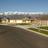 Curving street of single-level homes with snow-capped mountains